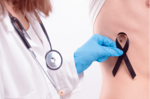 Doctor wearing white coat and stethoscope in gloves putting black ribbon on man’s skin.