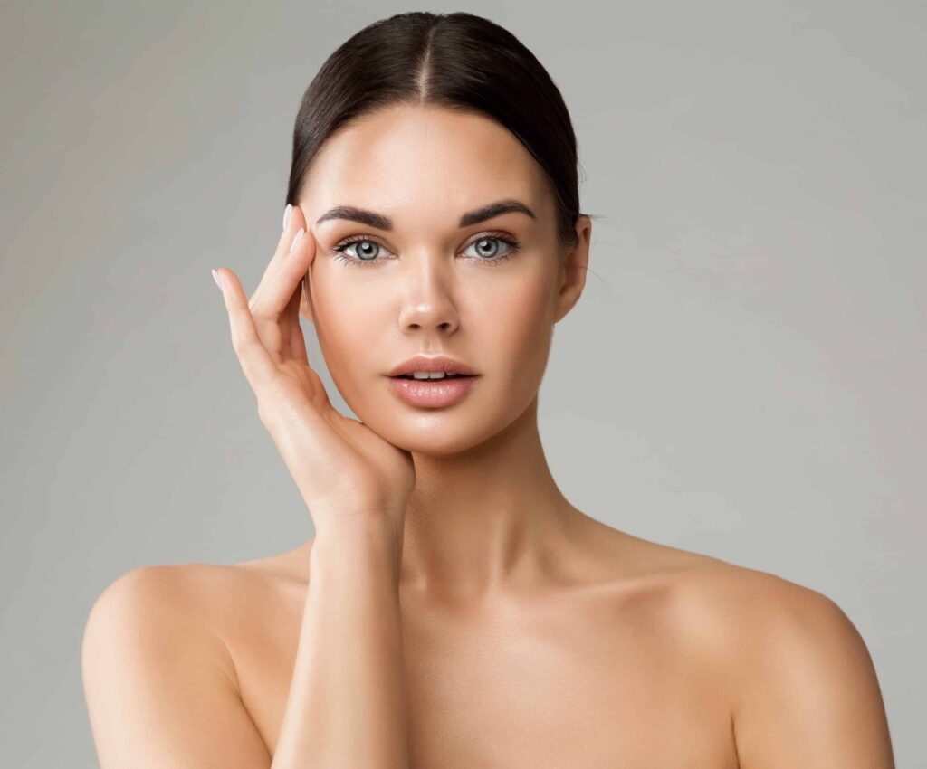 A woman framing her face with her hand, showing the results of RHA fillers